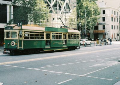 A green trolley car on a city street