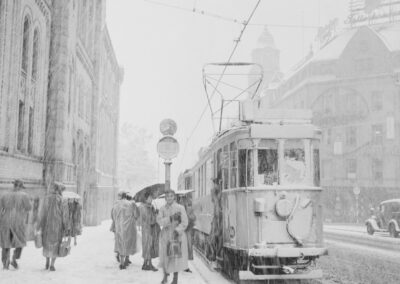 a black and white photo of a trolley on a snowy street